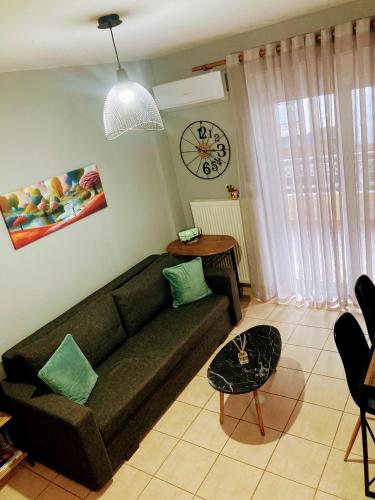 a living room with a couch and a clock on the wall at M.O.M.’s in Alexandroupoli