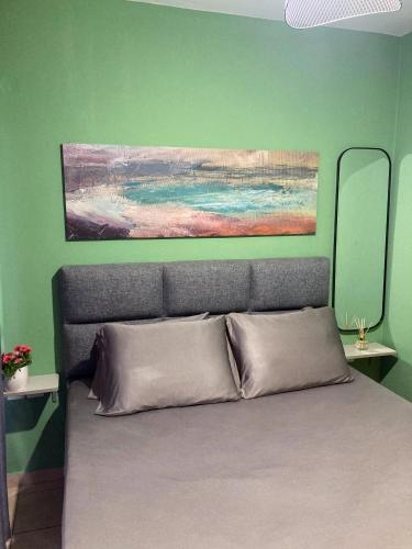 a bedroom with a bed with a painting above it at M.O.M.’s in Alexandroupoli
