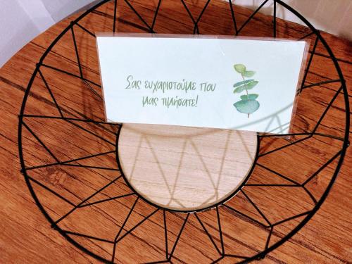 a sign sitting on top of a bowl on a wooden floor at M.O.M.’s in Alexandroupoli