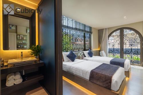 a bedroom with a bed and a sink and a window at Cubicity Wall Street House in Ho Chi Minh City