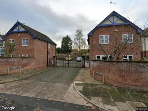 un bâtiment en brique avec une porte devant lui dans l'établissement Charming 3 Bedroom Apartment in Wythenshawe Convenient for Manchester Airport and City Centre Free Parking, à Wythenshawe
