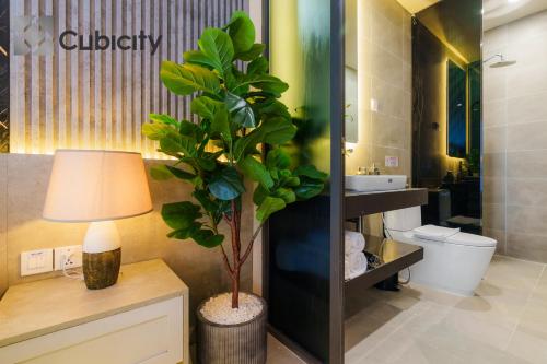 a bathroom with a plant and a lamp and a sink at Cubicity Wall Street House in Ho Chi Minh City