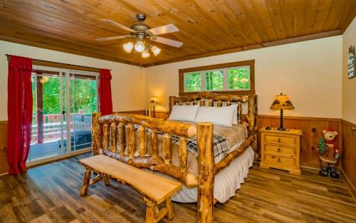 a bedroom with a wooden bed and a ceiling fan at Treetop Retreat in Gatlinburg