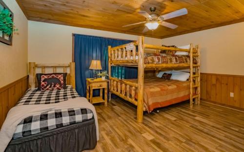 a bedroom with two bunk beds and a ceiling fan at Treetop Retreat in Gatlinburg