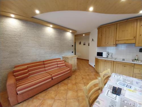 a living room with a couch and a kitchen at Residence Casa Federica in Valfurva