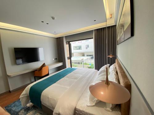 a hotel room with a bed and a window at Sally Hotel in Yen