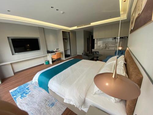 a bedroom with a large bed and a television at Sally Hotel in Yen