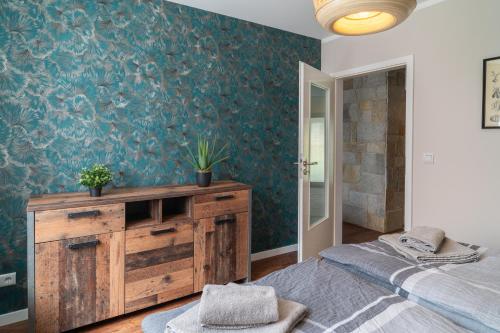 a bedroom with a bed and a wooden dresser at Appartment am Schafgartenweg in Hohndorf