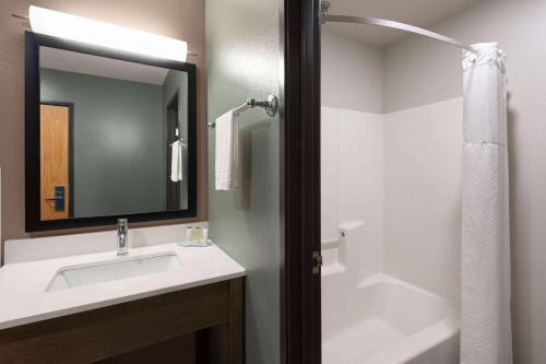 a bathroom with a sink and a mirror and a shower at Super 8 by Wyndham Big Timber in Big Timber