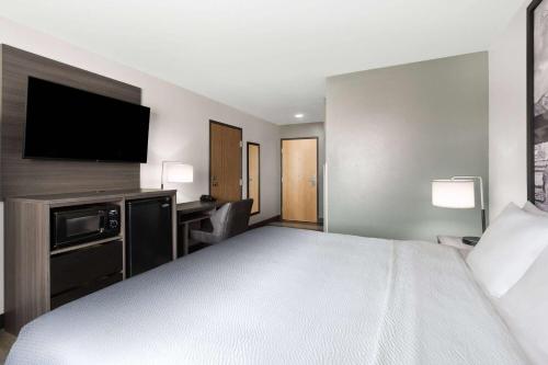 a hotel room with a bed and a flat screen tv at Super 8 by Wyndham Big Timber in Big Timber