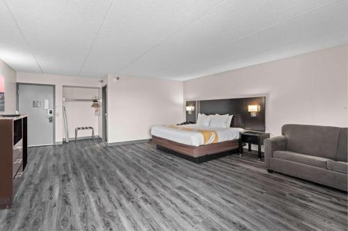 a hotel room with a bed and a couch at Quality Inn & Suites Mall of America - MSP Airport in Bloomington