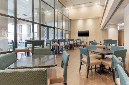 een eetkamer met tafels en stoelen en een tv bij Comfort Inn & Suites Johnstown - Richland Town Center in Johnstown