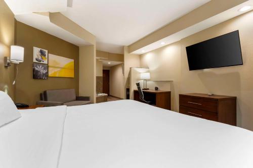 a hotel room with a bed and a flat screen tv at Comfort Suites Monaca in Monaca
