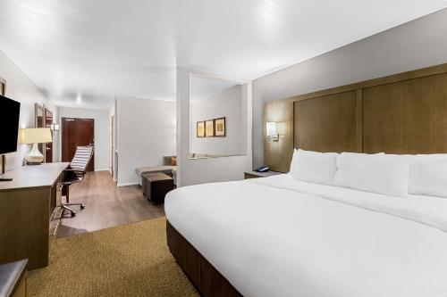 a hotel room with a large bed and a desk at Comfort Suites in Columbia