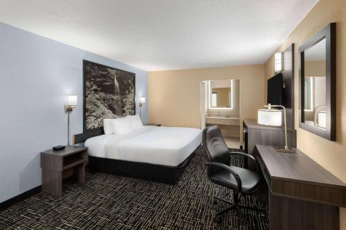 a hotel room with a bed and a desk and a chair at Super 8 by Wyndham Paducah I-24 Exit 4 in Paducah