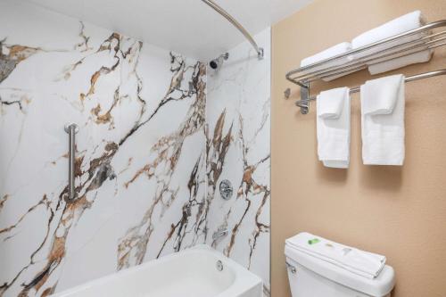 a bathroom with a shower and a toilet and towels at Super 8 by Wyndham Paducah I-24 Exit 4 in Paducah