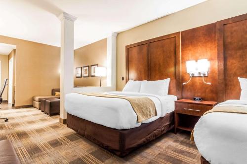a hotel room with two beds and a couch at Comfort Suites University Brookings in Brookings