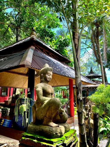 a statue of a woman sitting on a horse in front of a building at Baan Ton Rak Boutique Resort in Ko Chang