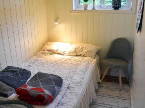 a small bedroom with a bed and a chair at 6 person holiday home in Åram-By Traum in Sandvik