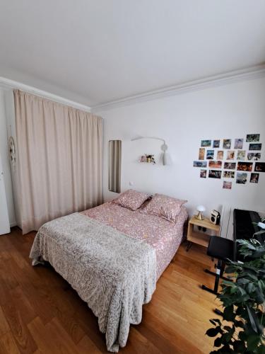 une chambre blanche avec un lit et une table dans l'établissement Charmant deux pièces typiquement parisien, à Paris