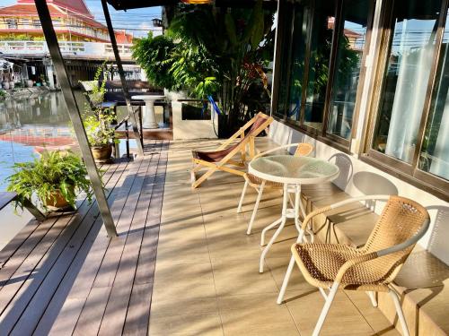 a balcony with a table and chairs on a building at Kirin Riverside Homestay with AC, WiFi in Bangkok in Rat Burana