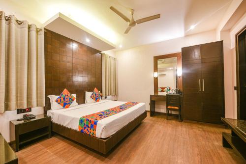 a hotel room with a bed and a bathroom at FabHotel Aashraye in New Delhi