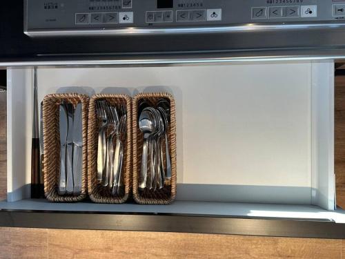 a drawer with utensils sitting on top of a microwave at ZABOCON YOICHI Villa in Yoichi
