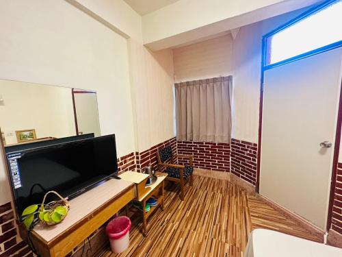 GukengにあるShi Bi Hotelのデスク、テレビ、鏡が備わる客室です。