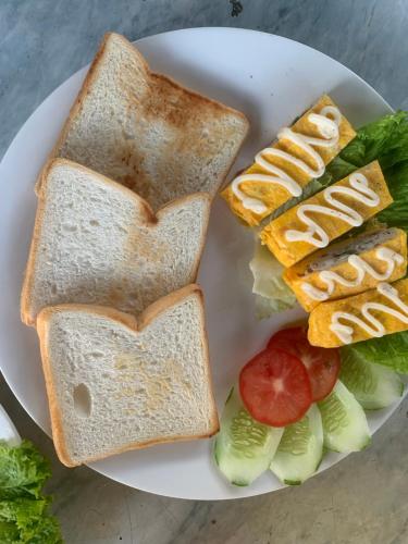 a plate with two slices of toast and vegetables at Peaceful refuge homestay in Ninh Binh