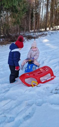 two children playing in the snow with a sled at Poiana Bucovat in Gura Humorului