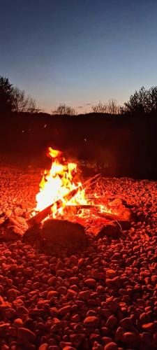 a fire burns on a rocky ground at night at Stodoła Rzym - domek, jacuzzi, sauna, jezioro, las in Kożyczkowo