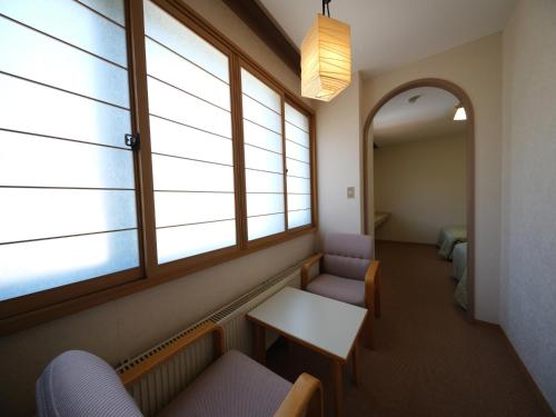 a waiting room with windows and benches and a table at REBUN Hotel SARYO in Kafuka