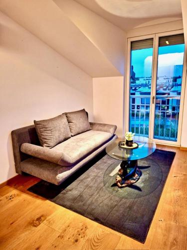 a living room with a couch and a glass table at Apartments C'EST LA SEA - Whirlpool-Suite oder Dachterrassen-Suite in Neusiedl am See