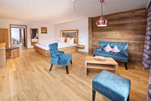 a hotel room with a bed and a blue couch at Ferienhotel Starennest in Schindelberg