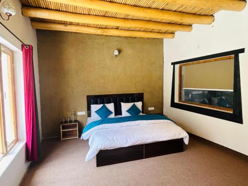 a bedroom with a large bed with a large mirror at Hunder Tamarix Resort in Hundar