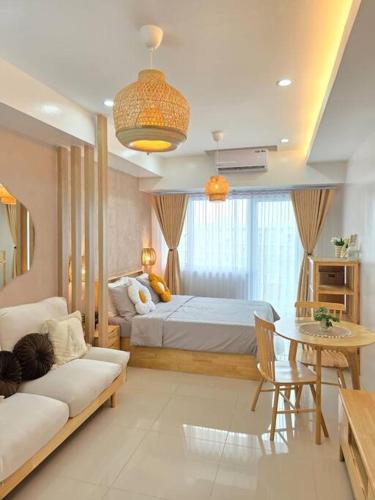 a bedroom with a bed and a table and a couch at Casa Angelica in Tagaytay
