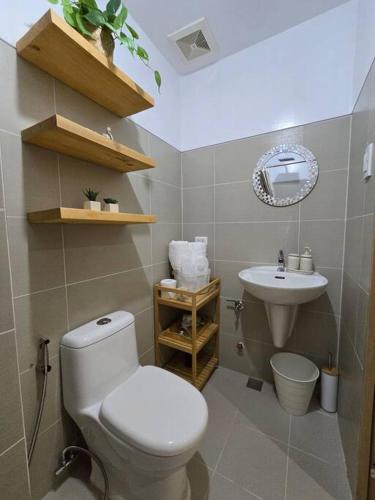 a bathroom with a white toilet and a sink at Casa Angelica in Tagaytay