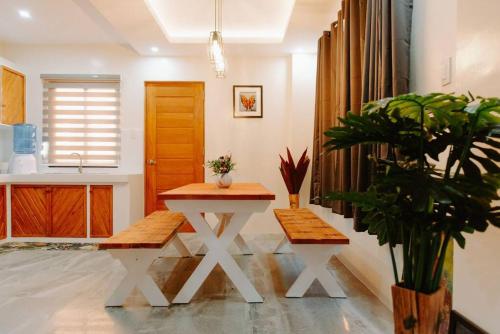 a living room with a table and two benches at Villa Naranja Pagudpud - Biondo in Pagudpud