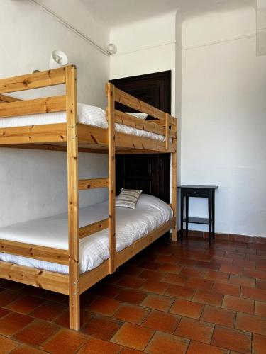 two bunk beds in a room with a table at Hôtel La Petite Bohème in Le Lavandou