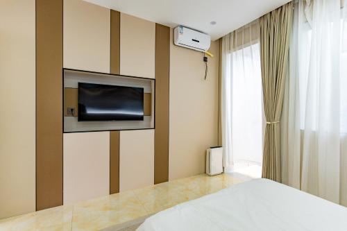 una camera da letto con un letto e una TV a parete di 在盐官民宿 a Hsü-chia-ch'iao