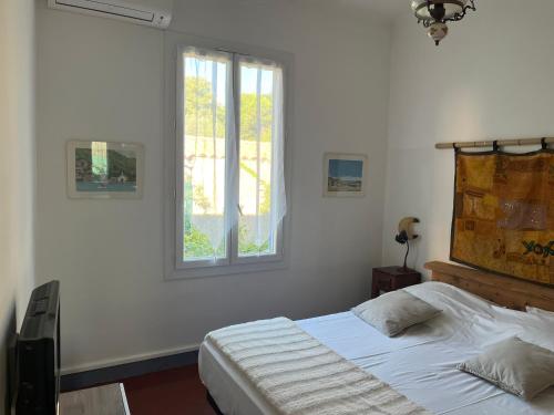 une chambre blanche avec un lit et une fenêtre dans l'établissement Villa Anna, à Antibes