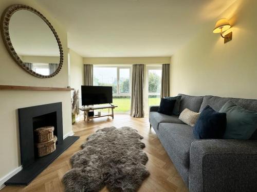 a living room with a couch and a fireplace at Beach Access-Ynys Cartref-4-Bed in Trearddur