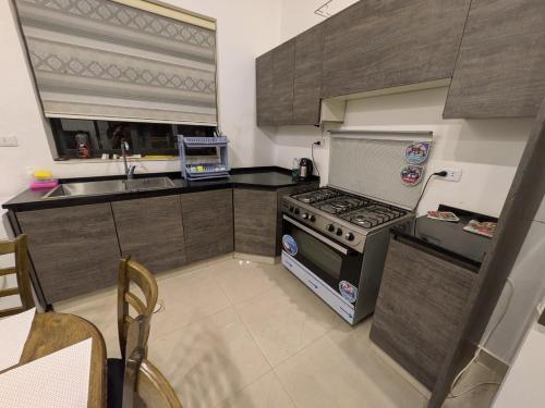 a kitchen with a stove and a sink at Aeropuerta Mini Villa - Private self check-in Layover near Amman Airport in Al Qasţal
