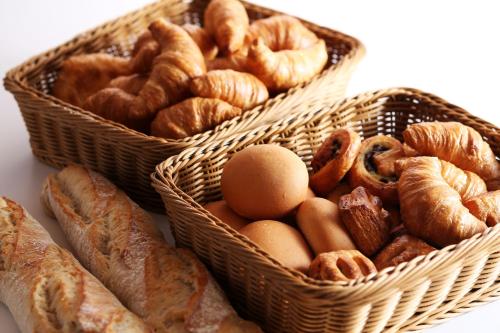 three baskets filled with different types of bread and eggs at Hotel Sakurai in Kusatsu