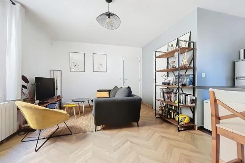 un salon avec un canapé et une table dans l'établissement Charming 2-Room Paris Getaway Near Le Marais, à Paris