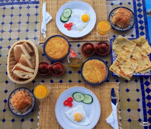 a table with plates of breakfast food on it at Casa Voyager 'secret garden terrace' in Chefchaouene
