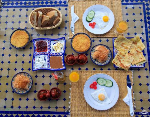 a table with plates of breakfast food on it at Casa Voyager 'secret garden terrace' in Chefchaouene