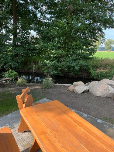 a wooden bench sitting in a garden with rocks at Landhaus-Ferienwohnung am Fluss in Plattenburg