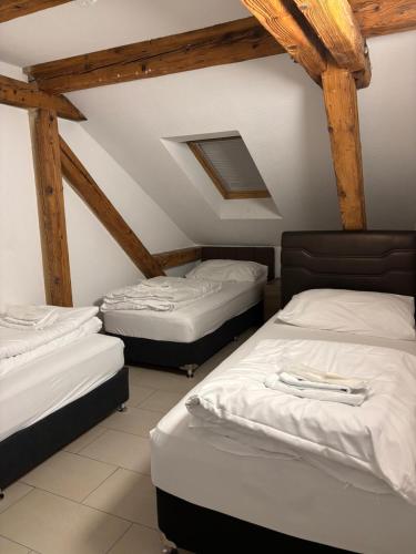 three beds in a room with wooden beams at Nani City Hotel in Zürich