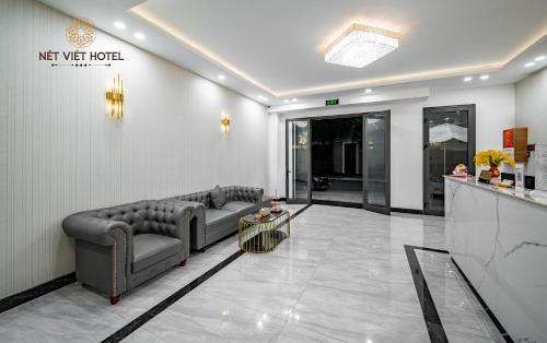 a living room with a couch and a table at Nét Việt Hotel Vincom Sóc Trăng in Soc Trang